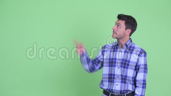 快乐的年轻英俊的西班牙男人一边说话一边指着视频的预览图