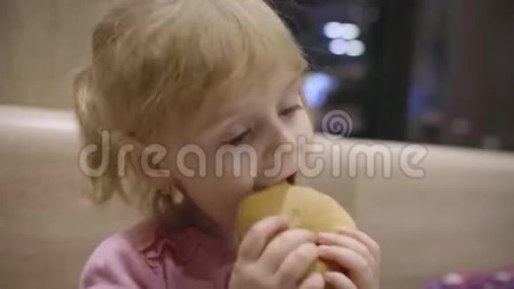 美丽快乐饥饿的女婴吃汉堡包概念儿童快餐视频的预览图