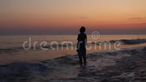 日落时海滩上悲伤沮丧的男人剪影视频的预览图
