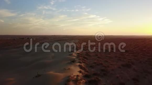 摄影师站在沙丘顶部拍摄沙漠视频的预览图