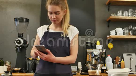 在工作场所使用手机的女性咖啡师视频的预览图