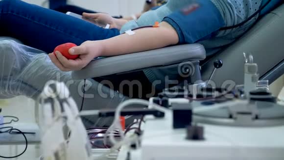 人们在诊所献血坐在工作机器附近的椅子上视频的预览图
