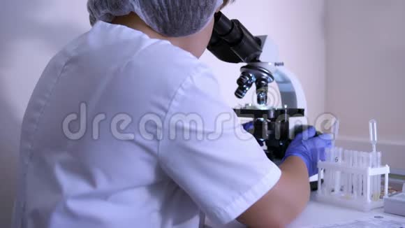 实验室里的女生物学家用显微镜工作视频的预览图