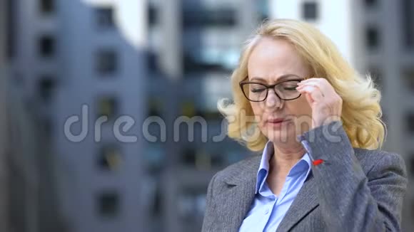患有偏头痛的成熟商业女性摘下眼镜工作疲劳视频的预览图