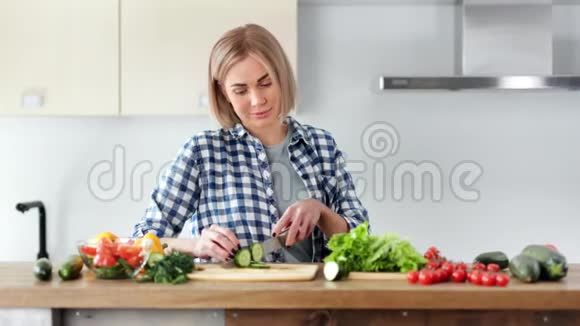 漂亮的纯素女人正在做新鲜的沙拉和尝试蔬菜看相机中镜头视频的预览图