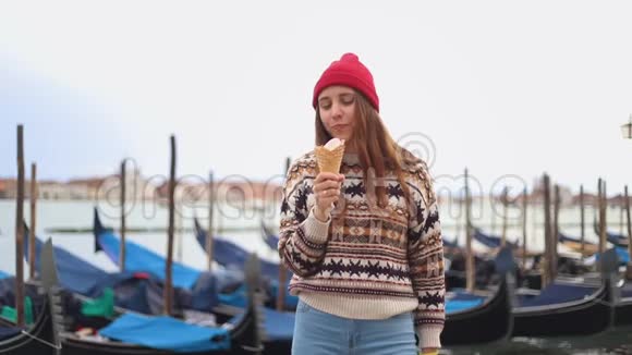 年轻的女人在蓝色的糖果店附近吃冰淇淋视频的预览图