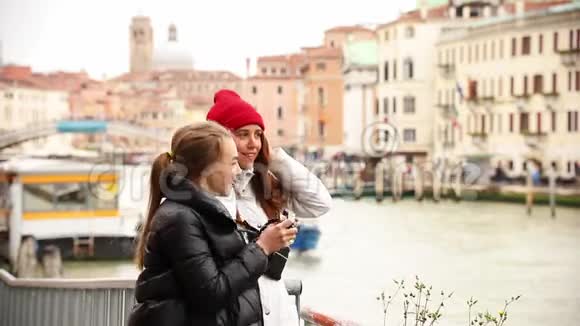 两个年轻的女人在威尼斯的街道上交谈和拍照视频的预览图