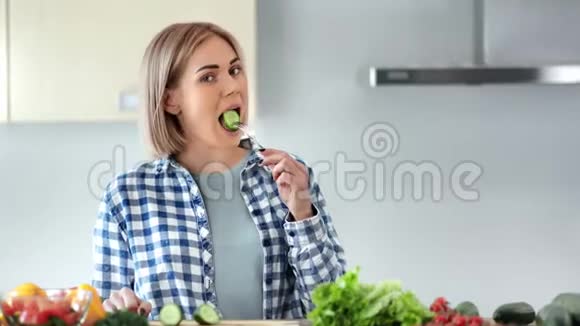 中等特写照片迷人的女人吃着美味的新鲜蔬菜看着相机视频的预览图