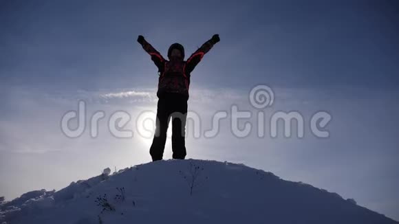 旅行者在一座雪山的山顶上为他的胜利而高兴跳起来挥动他的手臂一个快乐的人游客来了视频的预览图