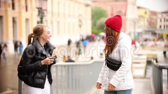 两个年轻的女人走在威尼斯的街道上关于他们告诉其他人如何站着拍照视频的预览图