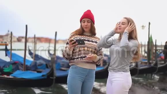 水岸上两个年轻的女人和船聊天自拍视频的预览图