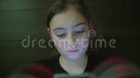 儿童少年女孩的夜镜头在平板电脑上轻映视频的预览图
