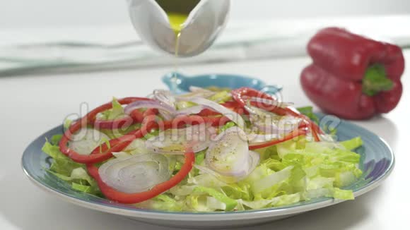 蔬菜沙拉在盘子里白色背景上特写新鲜有机生菜红胡椒洋葱一些调味料和ol视频的预览图