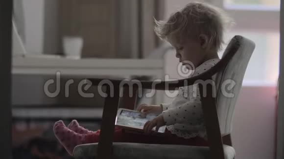 一个小女孩坐在椅子上腿上放着一块药片视频的预览图