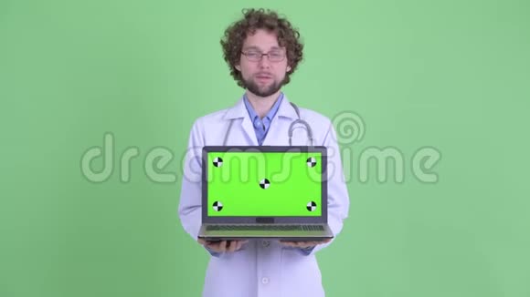 快乐的小胡子男医生一边看着笔记本电脑一边说话视频的预览图