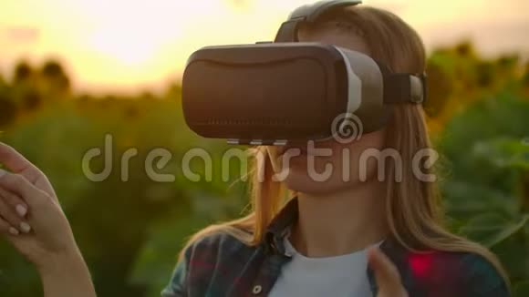 日落时分女孩在向日葵田上使用VR眼镜视频的预览图