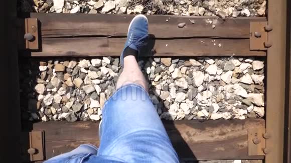 旅行者的腿在铁路上系着特写镜头游客踩着枕木乘客落后于火车视频的预览图