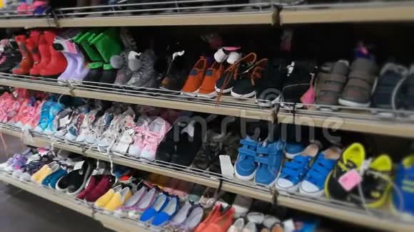 商店里有男孩女孩和儿童鞋的架子儿童鞋运动鞋和各种彩色靴子视频的预览图