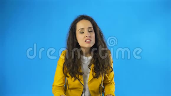 一个非常愤怒和沮丧的女人在工作室蓝色背景视频的预览图
