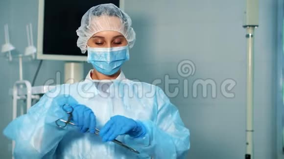 手术室的一名护士拿起两个医疗夹子视频的预览图