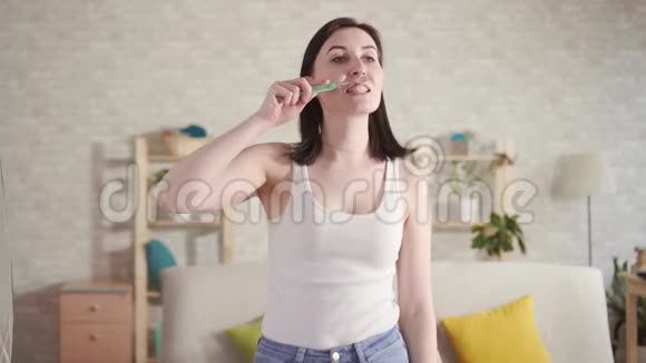 年轻女子在刷牙时注意到刷子上的血和口腔疼痛牙龈出血的概念视频的预览图