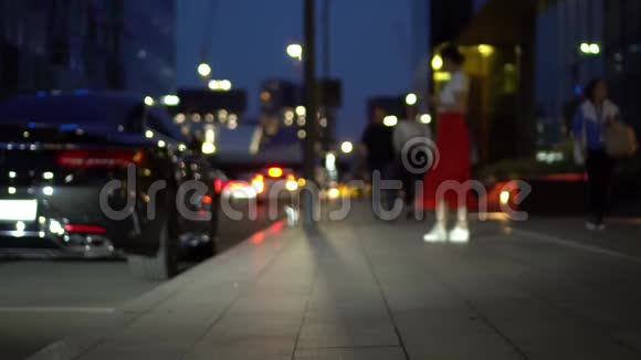 人们在散步穿着红色裙子的女孩在人行道上晚上慢动作视频的预览图