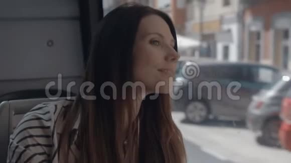 一个长发女孩坐在公共汽车上看着窗外视频的预览图