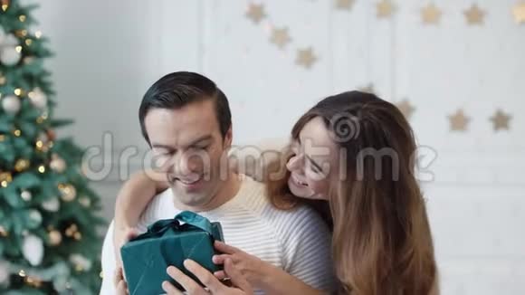 快乐的男人在豪宅里得到新年礼物微笑的女人拥抱男人视频的预览图