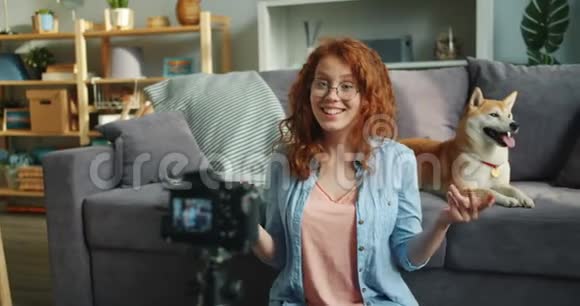 快乐的女人用专业的摄像机录制关于狗的视频视频的预览图