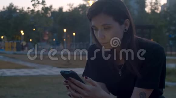 公园里有智能手机的年轻女子视频的预览图
