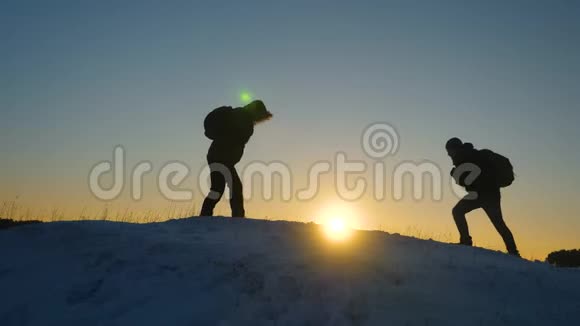 登山者在雪山顶上相遇享受他们的成功举起手快乐地跳跃团队合作视频的预览图