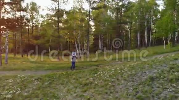 一对走在山路上的年轻夫妇女背驮男朋友视频的预览图
