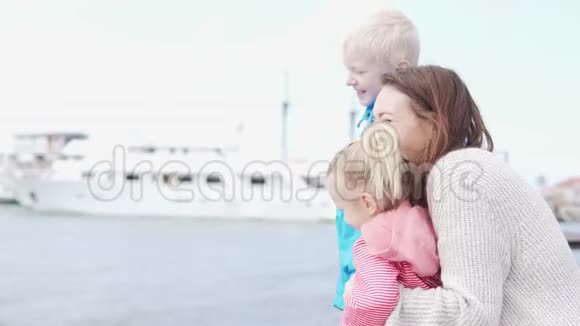 在一个凉爽的春天一个女人和她的孩子们正在看着大海视频的预览图