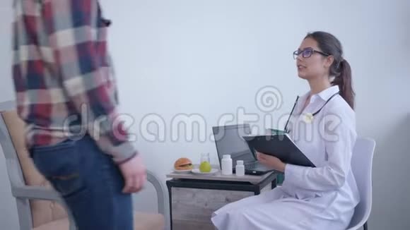 医生营养学家女士握手帮助病人男性制定健康和健康体重的饮食计划视频的预览图