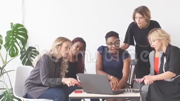 积极的妇女一边坐在笔记本电脑桌上讨论组织计划视频的预览图