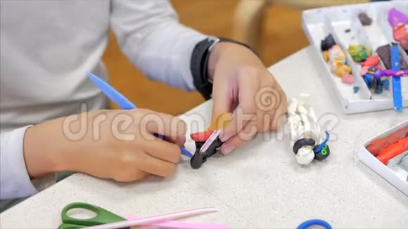 孩子们手特写孩子们用塑料在桌子上雕刻孩子们画的发展圈视频的预览图
