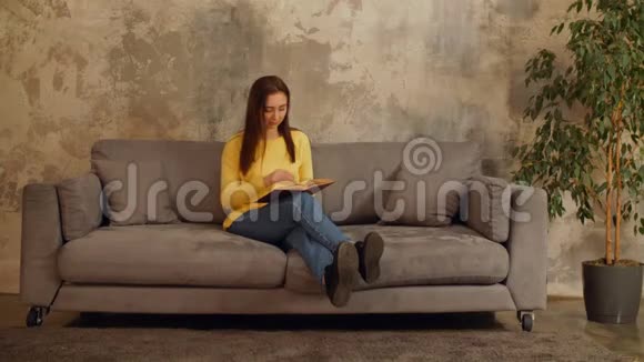 聪明的女人在沙发上看书视频的预览图