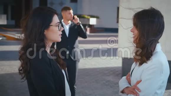 两个漂亮的商业女人互相交谈他们聊天一起玩在后台办公楼里视频的预览图