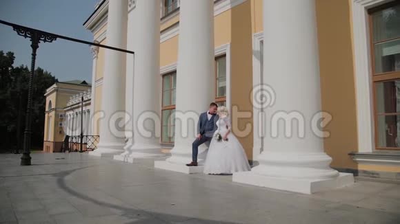 快乐的新婚夫妇站在公园的柱子上视频的预览图