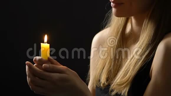 平和微笑的女士手持燃烧的蜡烛希望更好信仰和信念视频的预览图