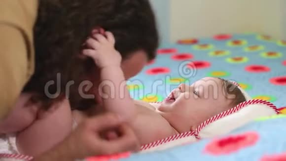 可爱的快乐父亲在托儿所和婴儿玩耍胡子爸爸吻他的孩子很美的光爱的概念视频的预览图