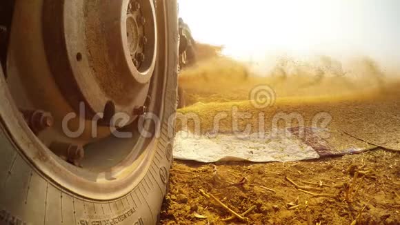 拖拉机轮在前面截草机机制抛出切碎的茎在大堆农民工作后沙漠村拉贾斯坦视频的预览图
