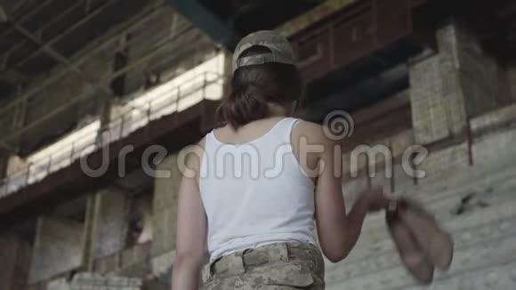 一个穿着军装的年轻女子把高跟鞋放在肩上微笑着看着镜头这就是视频的预览图