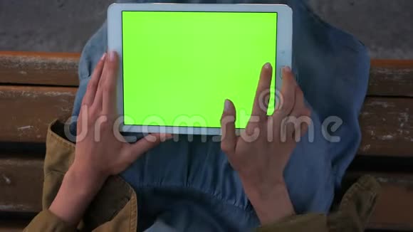年轻女子手里拿着平板电脑做着滑动敲击手势视频的预览图
