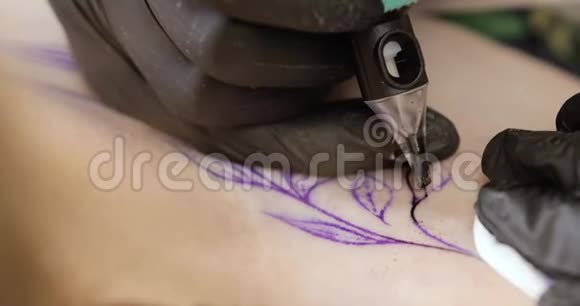 带有针的纹身机的特写镜头是在皮肤上纹身黑色的叶子视频的预览图