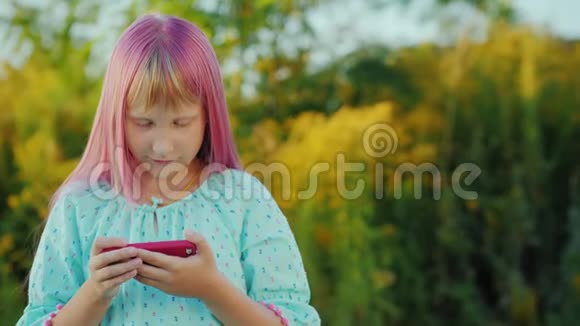 粉红头发的女孩在户外使用智能手机视频的预览图