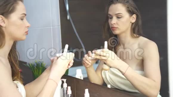 在浴室镜子前化妆的漂亮女人视频的预览图