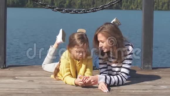 暑假期间快乐的妈妈和孩子一起躺在码头上视频的预览图