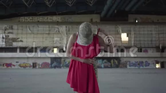 漂亮的年轻女子穿着军装穿着红色的衣服在废弃的建筑里翩翩起舞这就是视频的预览图