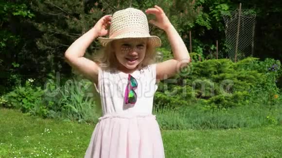 顽皮的金发女孩扔掉帽子穿粉色裙子的快乐女孩万向节运动视频的预览图